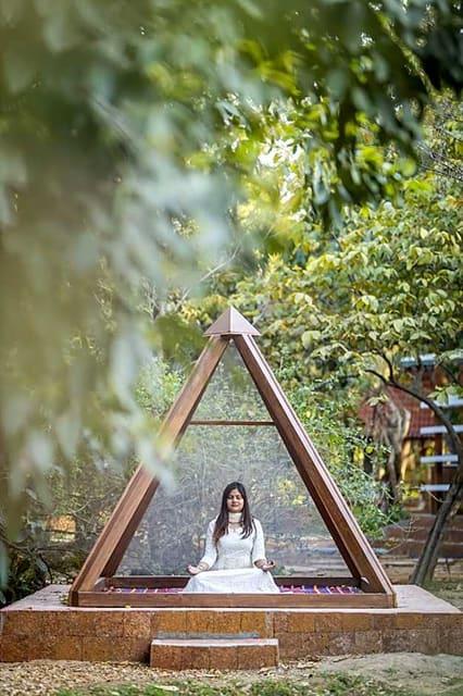 Méditation sous la pyramide de bois du jardin